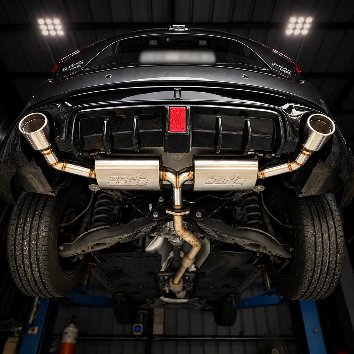 Dual axleback exhaust with two mufflers under a black sports car