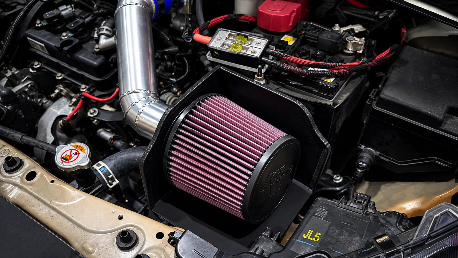 Custom aluminum intake with a heatshield around the filter