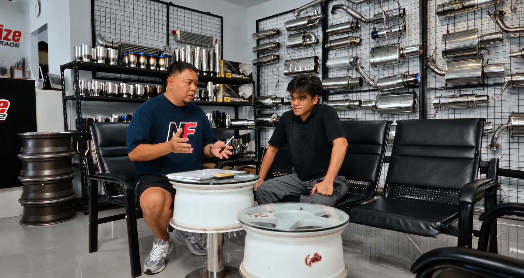 Kuya Ron sitting down with a customer in the Nitrofuze showroom, talking through exhaust options