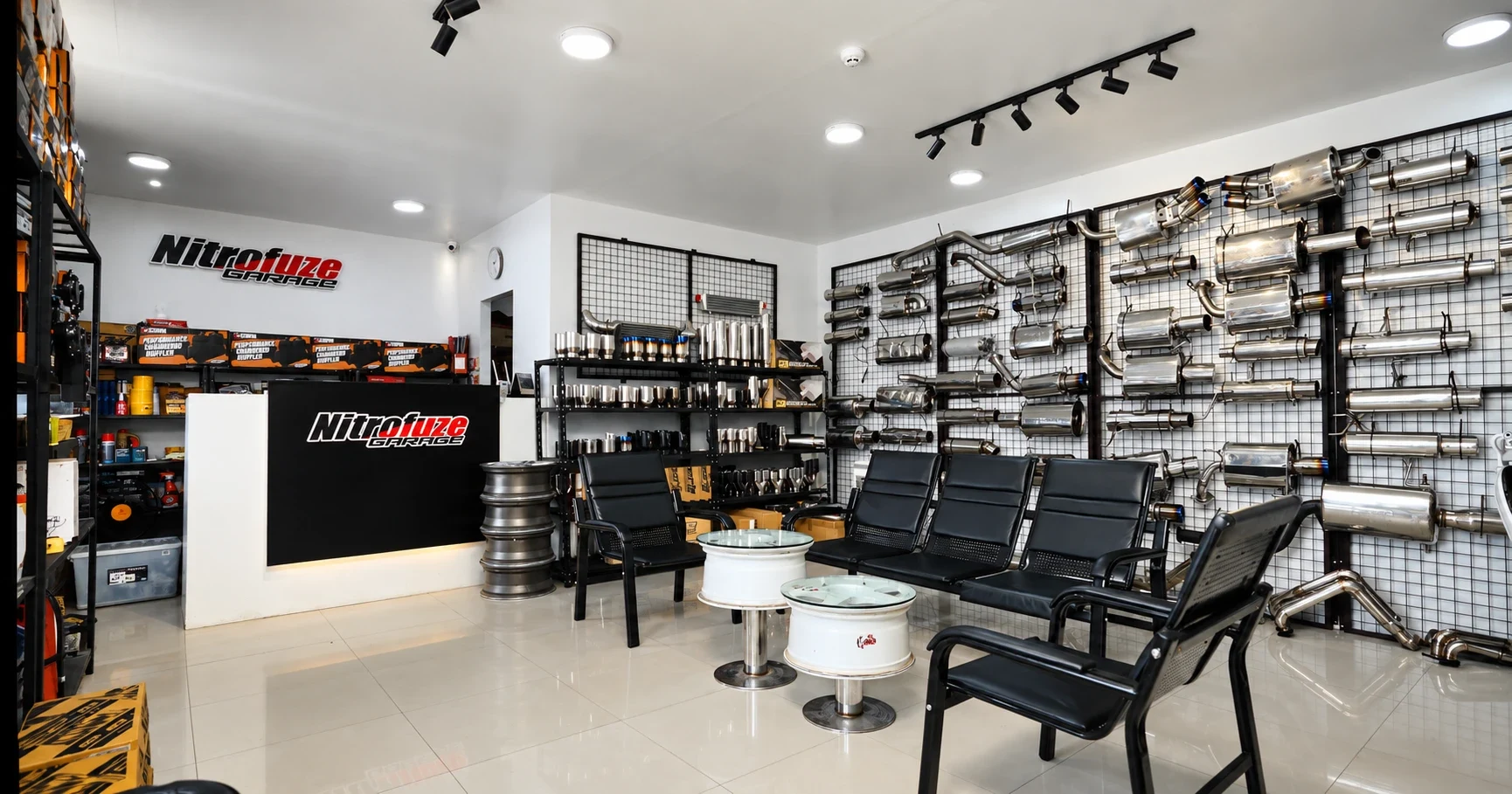 Customer waiting area with a wall of stainless mufflers