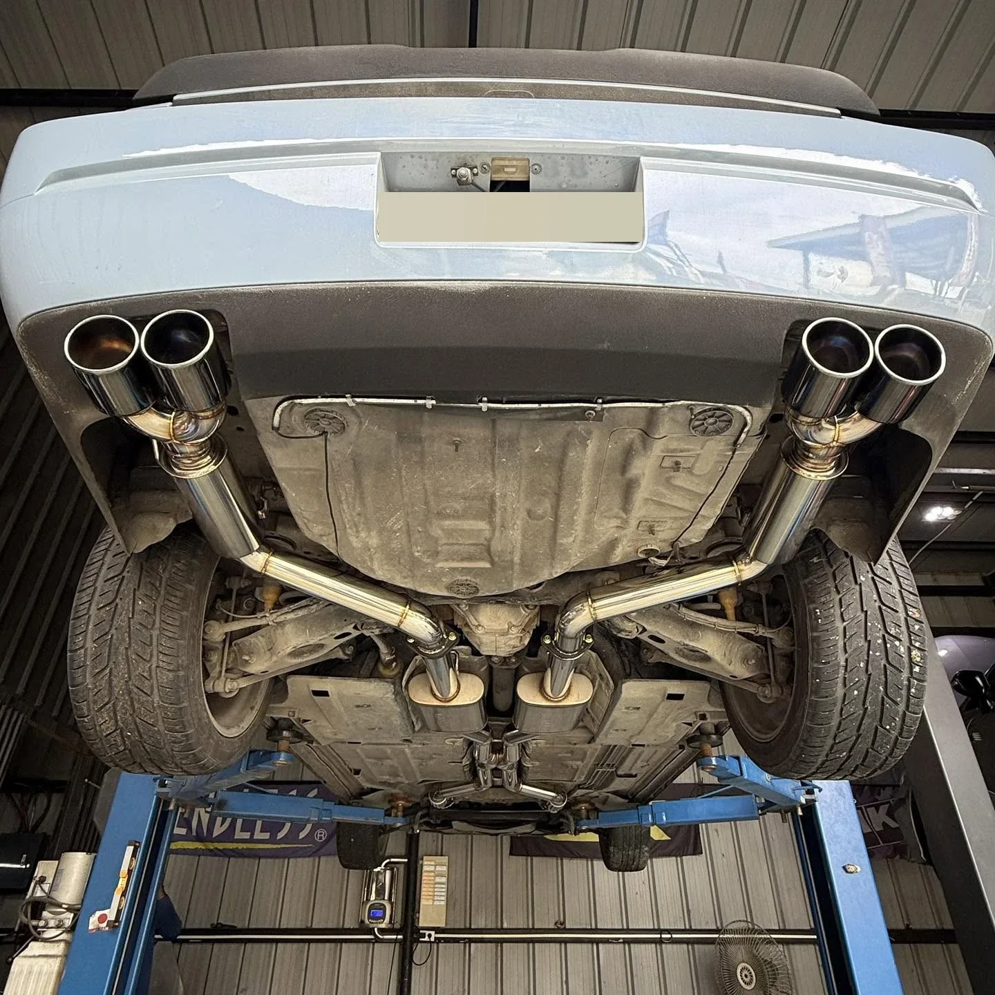 Underside of a Dodge Challenger V6 on the lift showing the stainless X-pipe catback, Magnaflow and G-pipe mufflers and quad tips