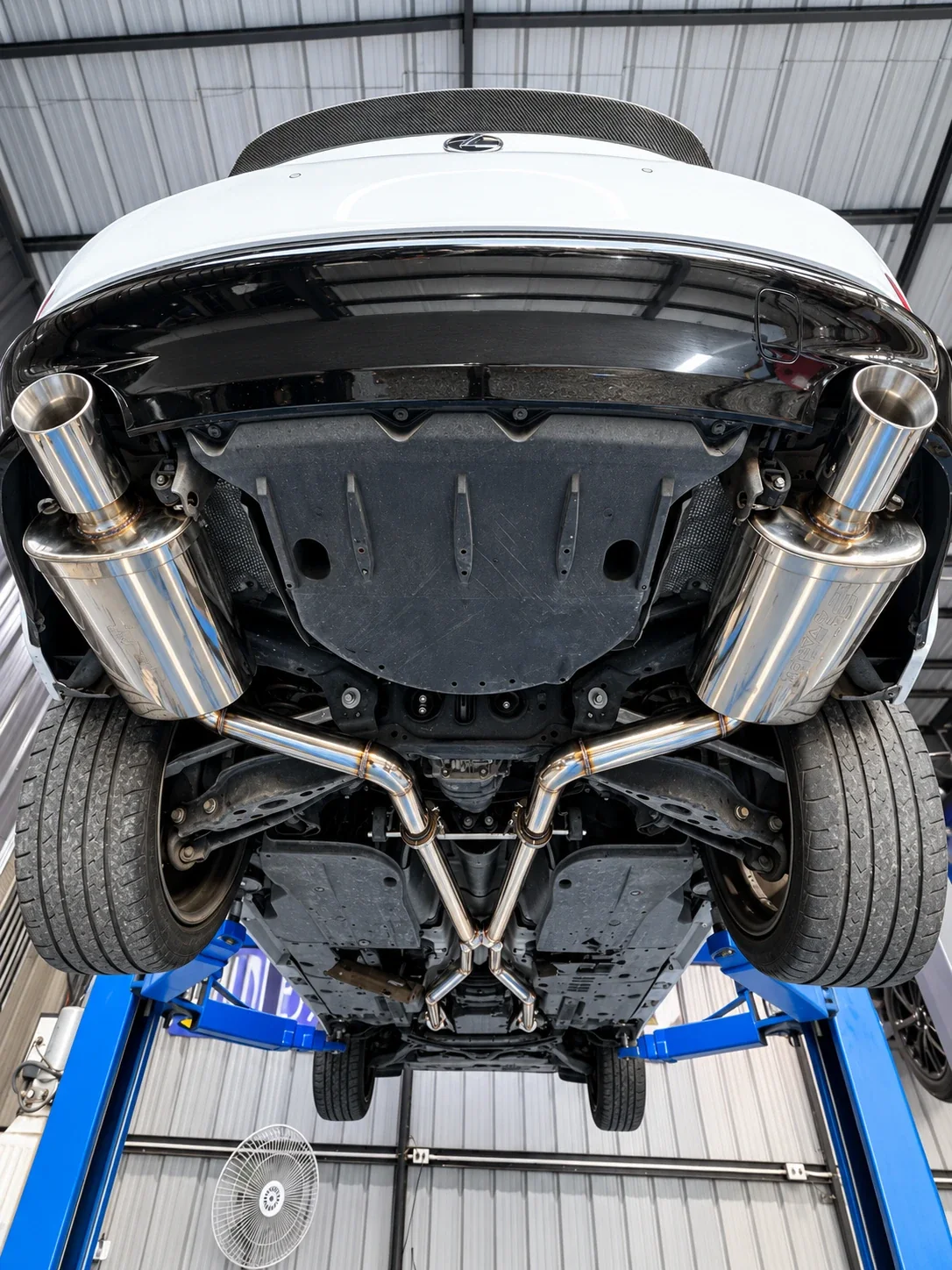 Underside of a Lexus IS 350 on the lift showing the stainless full exhaust with X-pipe and dual Varex mufflers