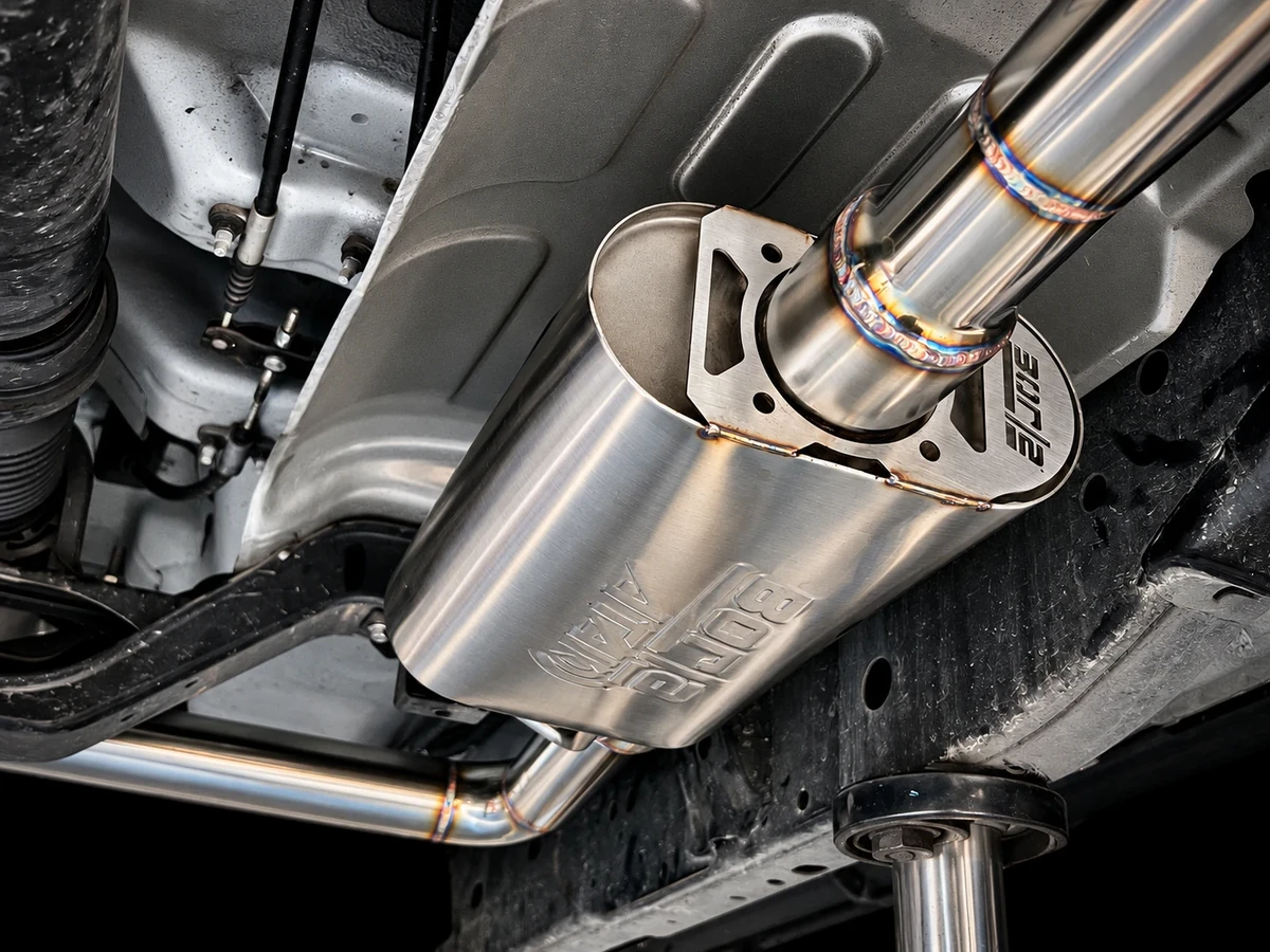 Borla ATAK muffler installed under a car, with the stainless pipework and welds visible
